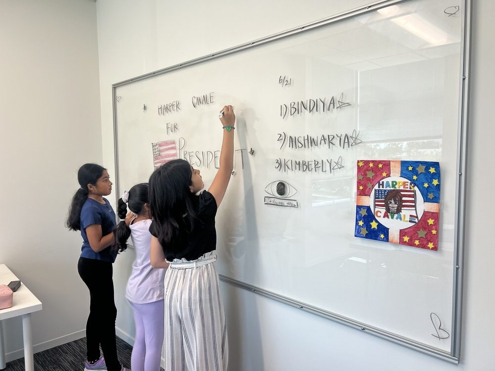 Children writing on white board - Cogito Debate